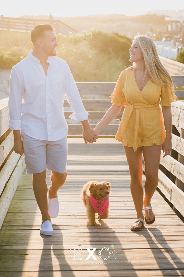 couple and their dog walking on the boardwalk in Long Beach