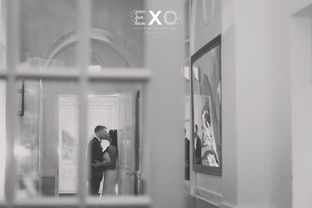 bride and groom kissing in the doorway of The Mansion at Oyster Bay