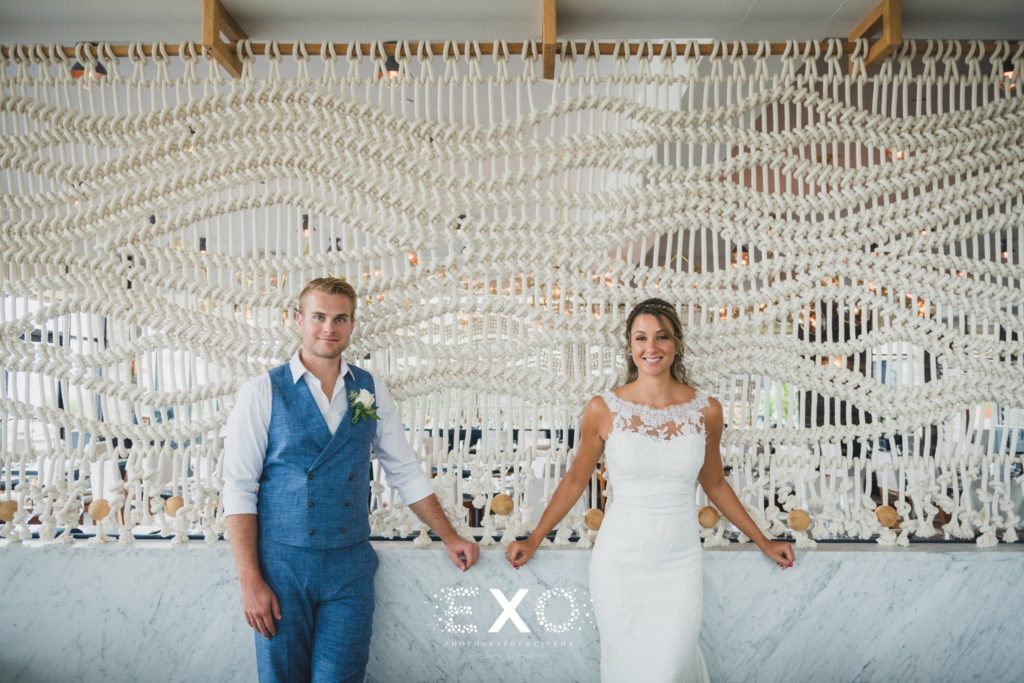bride and groom posing by crochet wall at Gurney's Montauk Resort