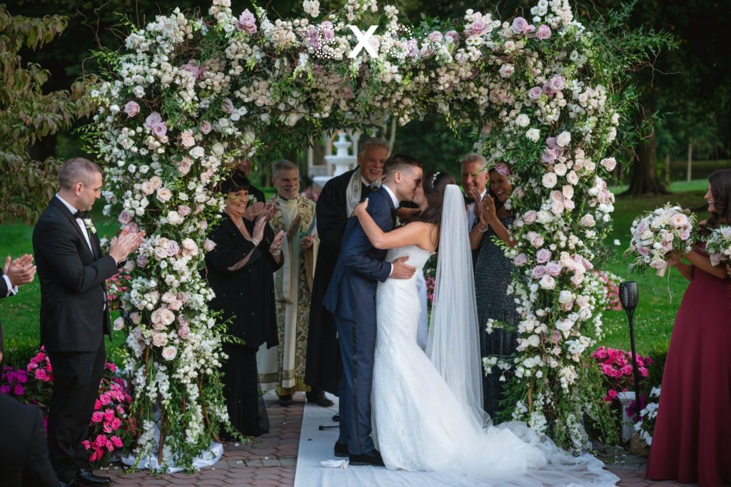 bride and groom kissing "I do" under the stunning chuppah