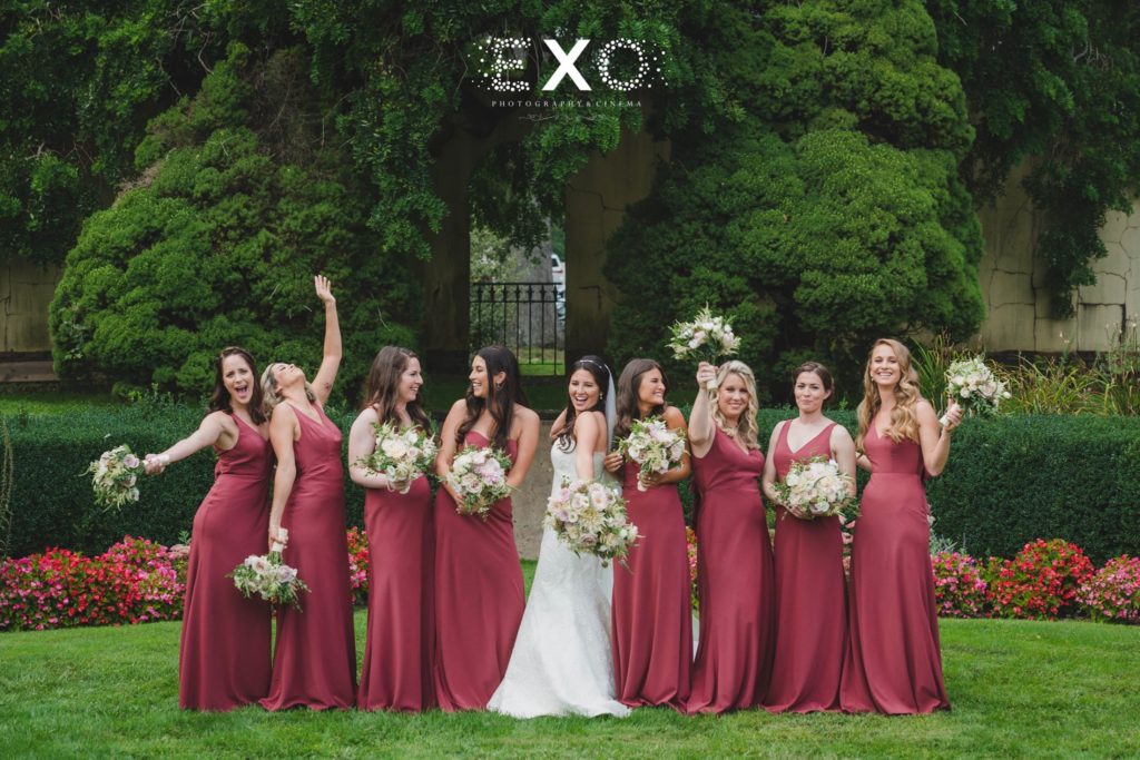 bride and her bridesmaids in the garden of The Mansion at Oyster Bay