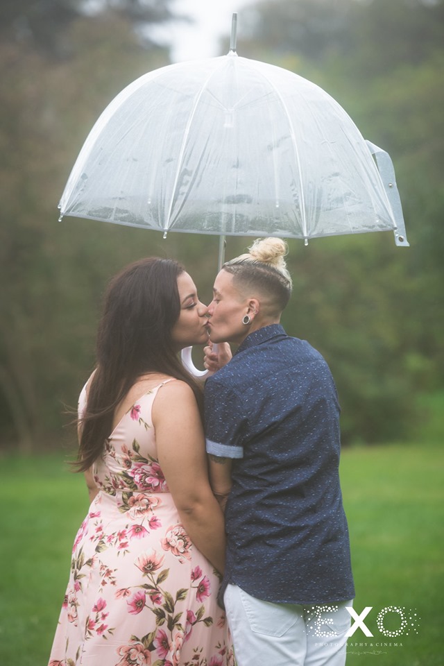 couple kissing under an umbrella at Planting Fields Arboretum