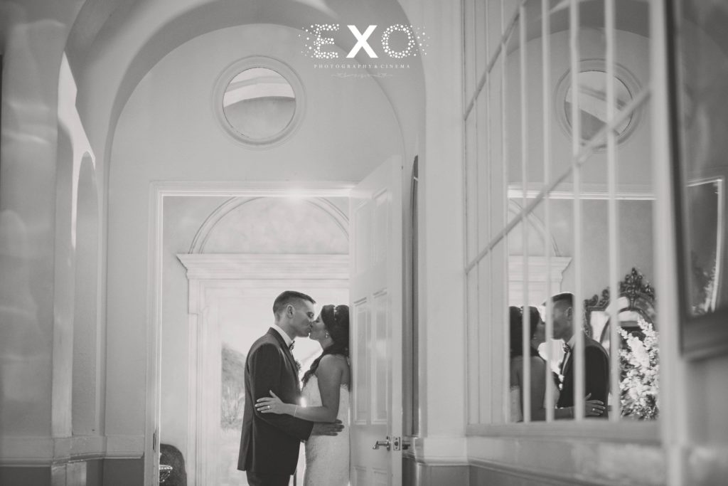 bride and groom kissing in the doorway at The Mansion at Oyster Bay