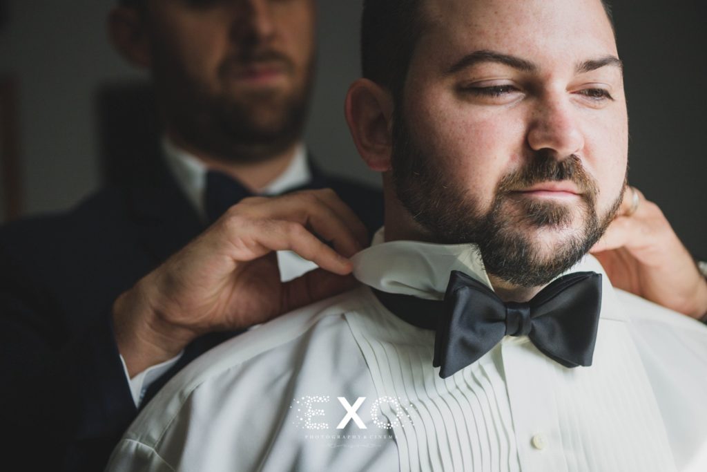 groom getting help with his bowtie