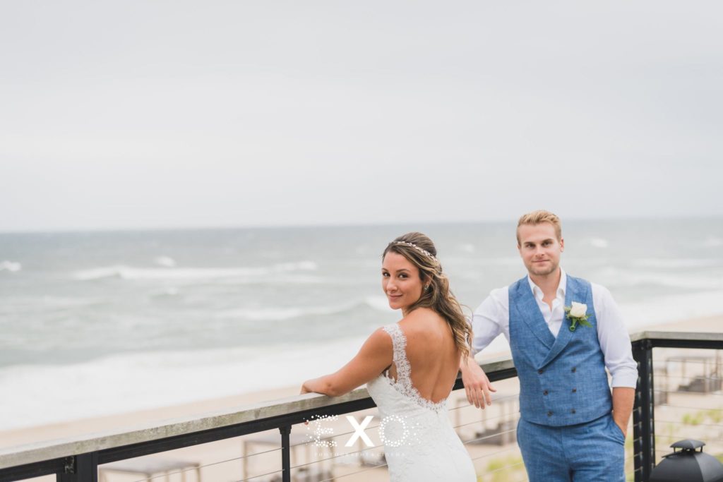 bride and groom standing by balcony outside Gurney's Montauk Resort