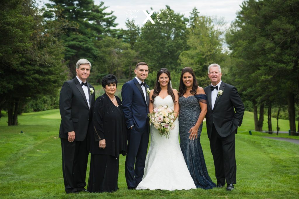 bride and groom with parents outside The Mansion at Oyster Bay