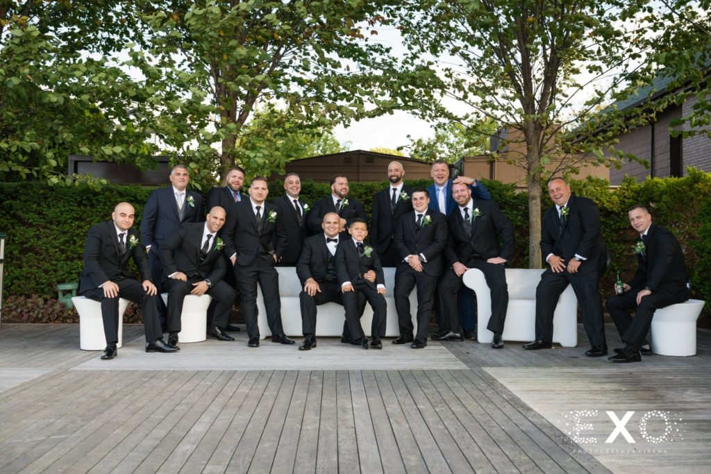 groom and groomsmen posing outside Harbor Club at Prime