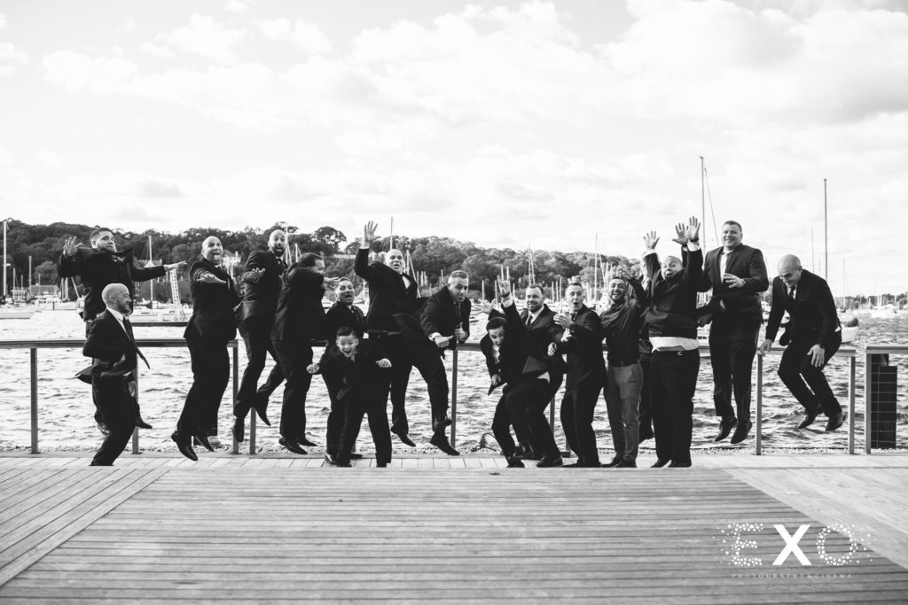 groomsmen being silly outside Harbor Club at Prime
