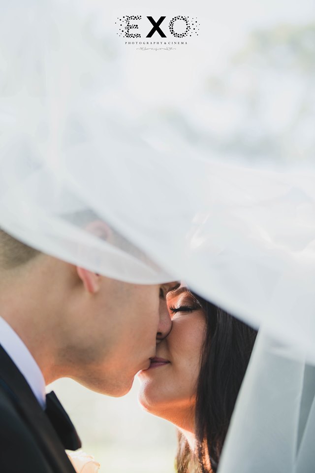 bride and groom kissing under bride's veil at The Muttontown Country Club