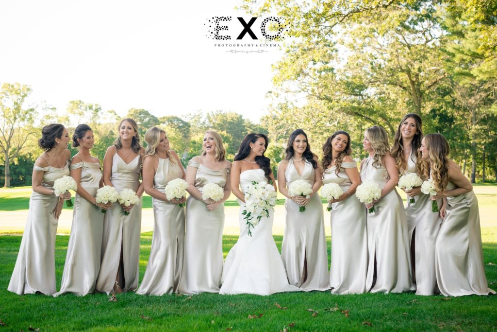 bride and bridesmaids posing outside The Muttontown Country Club