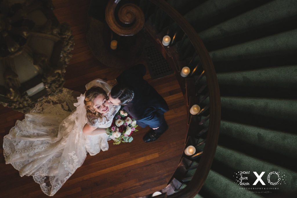 bride and groom kissing below the stairwell at Coindre Hall