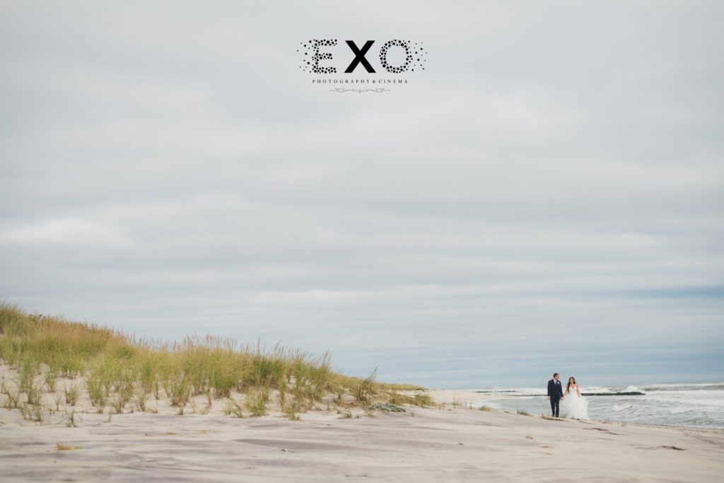 bride and groom walking along the beach at Oceanbleu