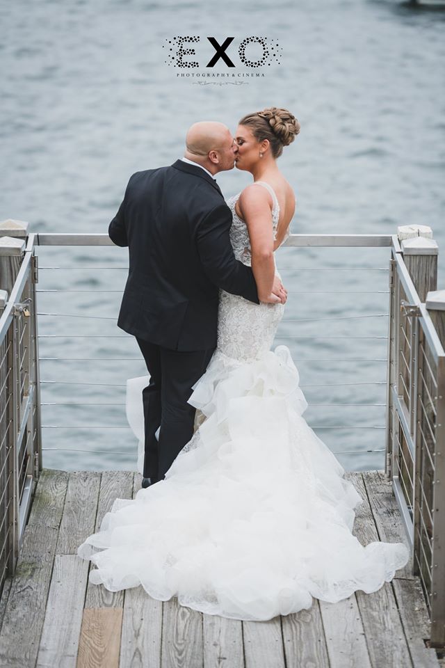 bride and groom kissing, overlooking the water at Harbor Club at Prime