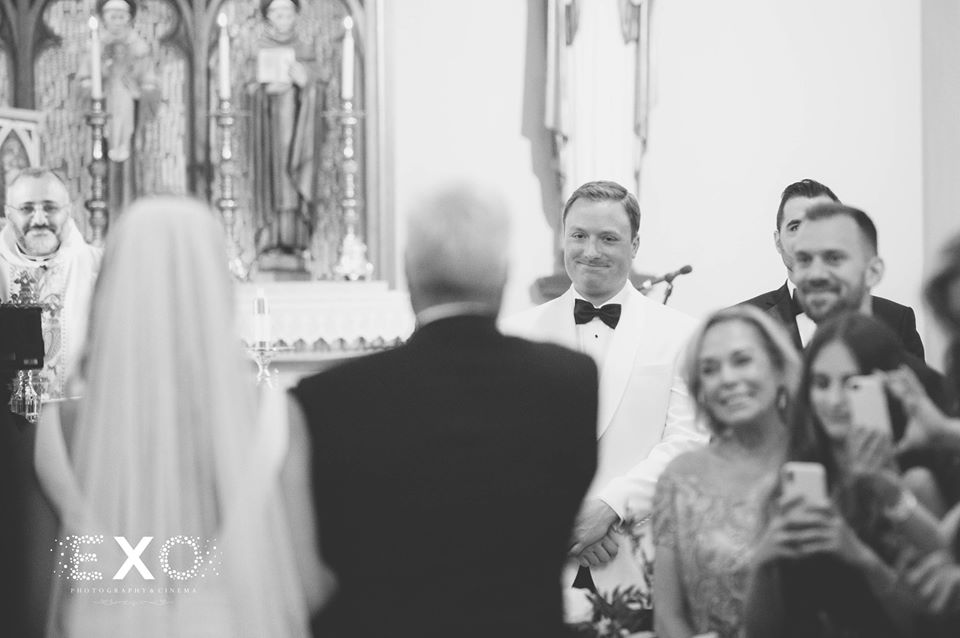 groom staring at his bride as she walks down the aisle
