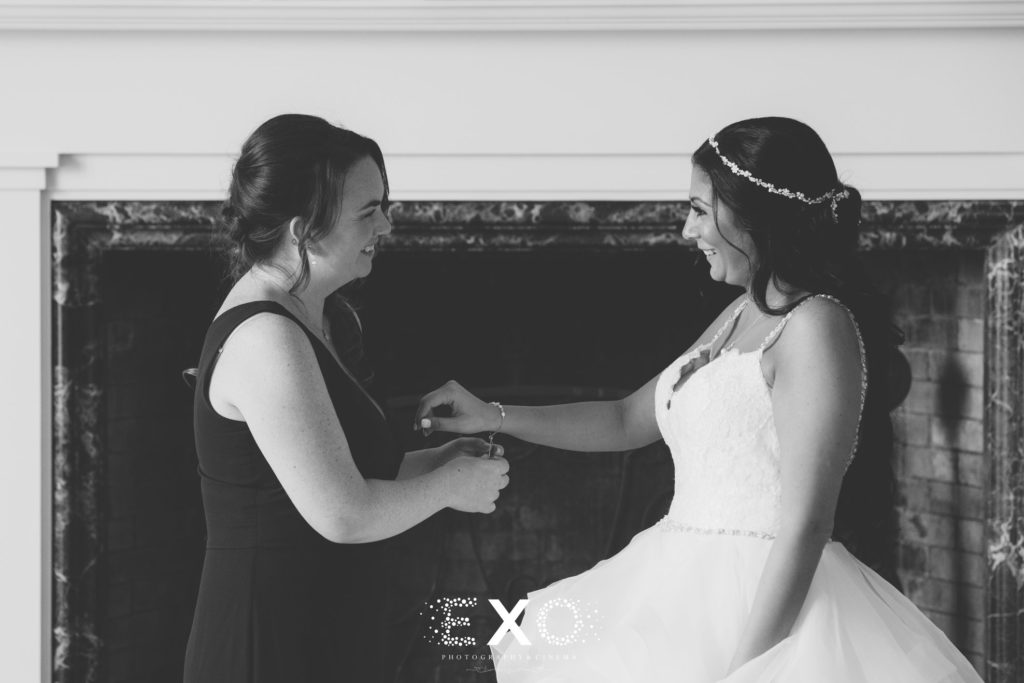 bride getting help from bridesmaid with her bracelet