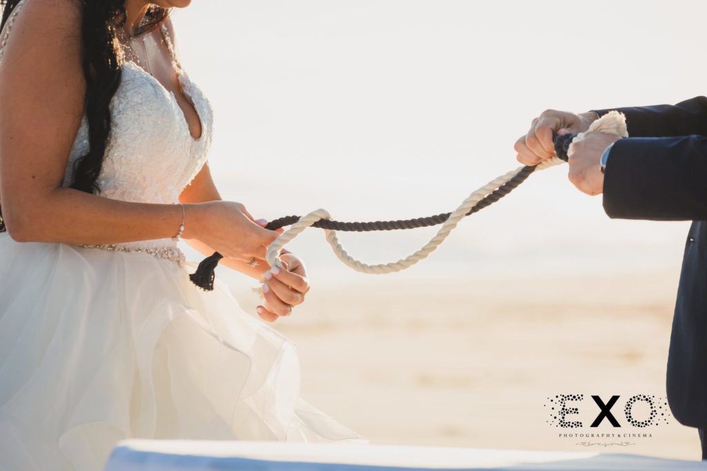 bride and groom tying rope during ceremony at Oceanbleu