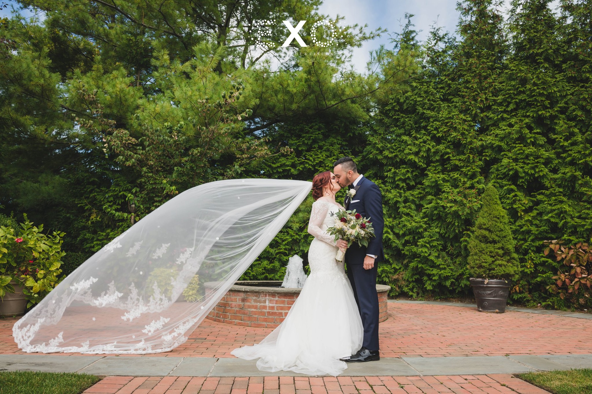 bride and groom kissing outside Crest Hollow Country Club