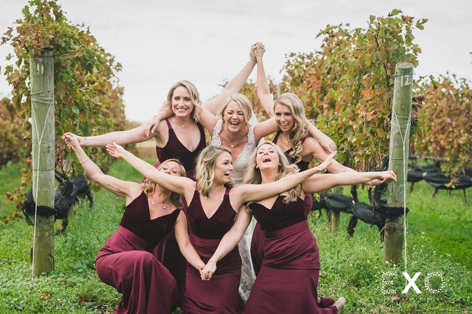 bride and her bridesmaids laughing in the vineyard at The Vineyard at Aquebogue