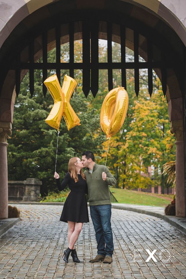 couple kissing holding XO balloons at Vanderbilt Museum