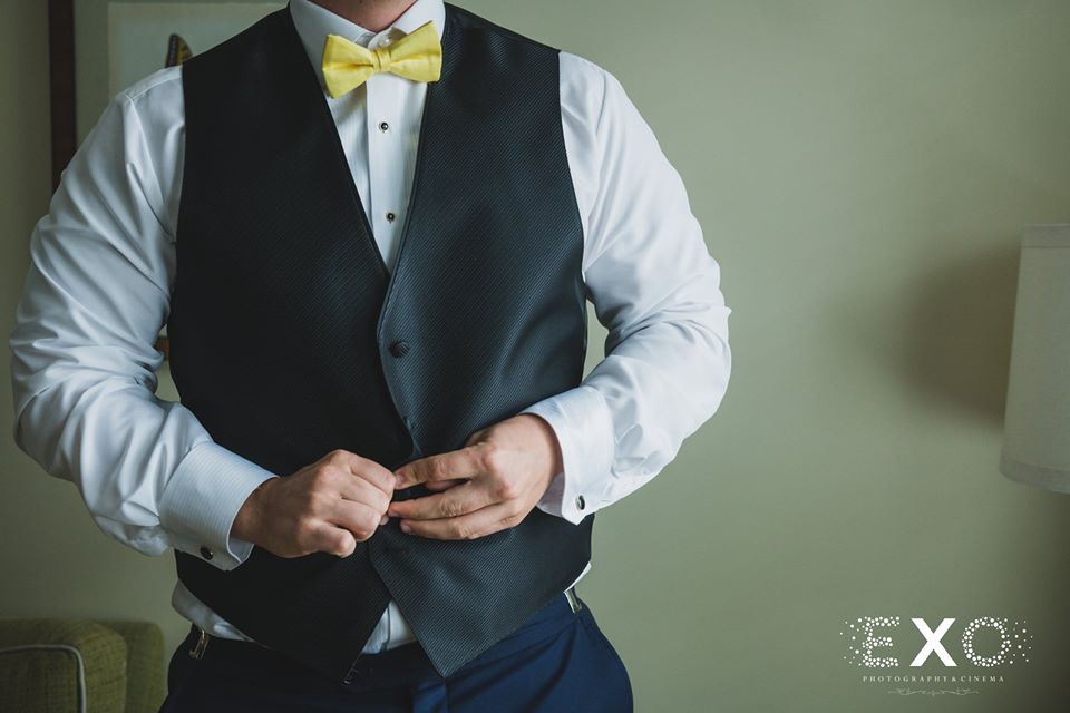 groom buttoning up his vest