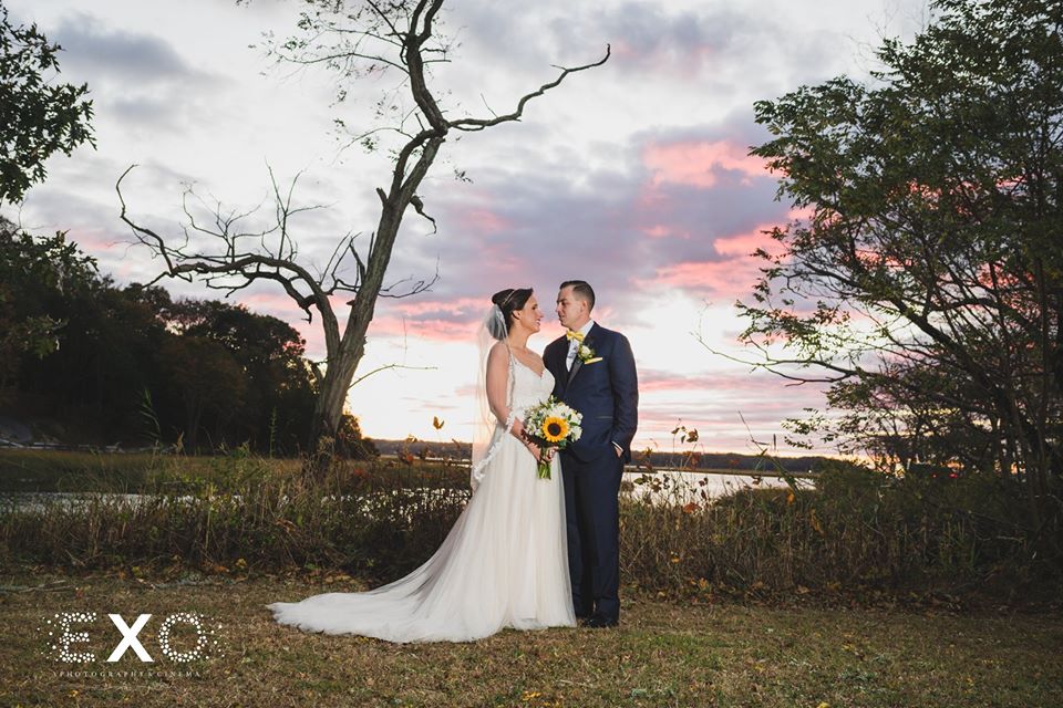 bride and groom outside Three Village Inn during sunset
