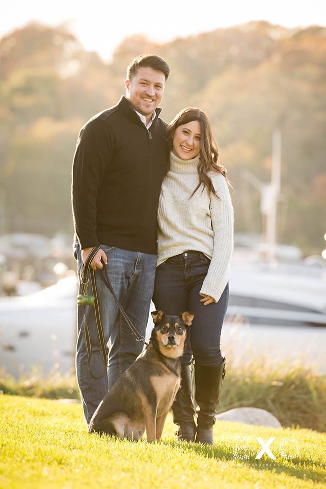 couple smiling with their adorable dog