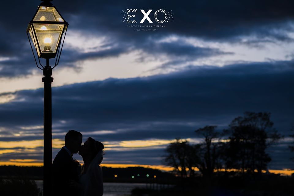 bride and groom kissing by the lamppost at night
