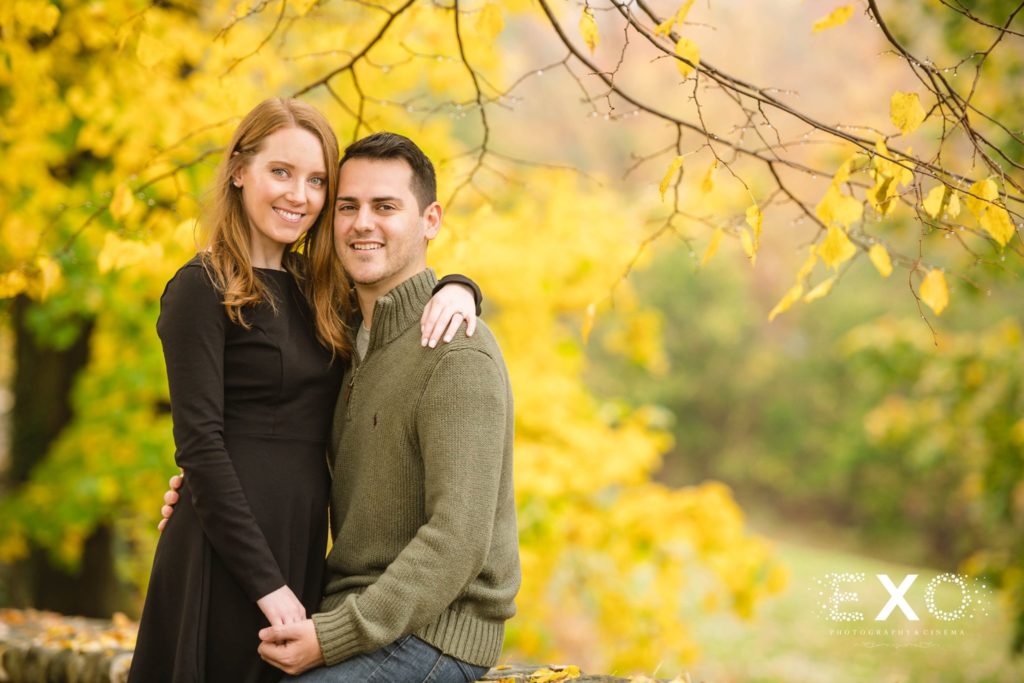 couple smiling at Vanderbilt Museum with fall foliage