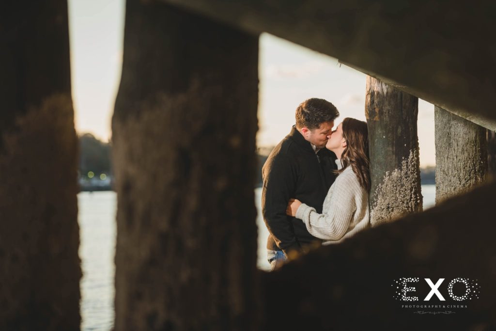 couple kissing under the boardwalk