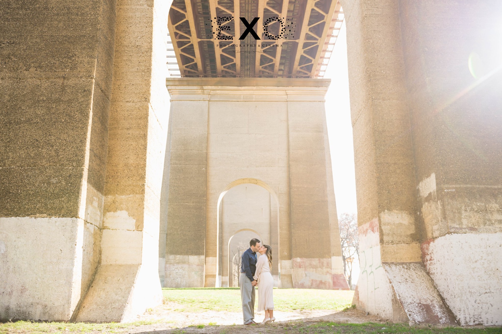 couple kissing under the archway in Astoria Park