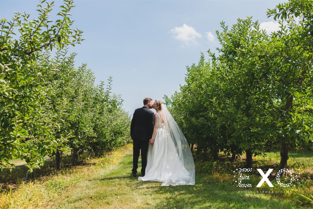 bride and groom kissing among the trees at Salt Air Farm