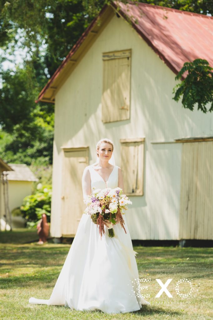 bride posing with her bouquet at Salt Air Farm