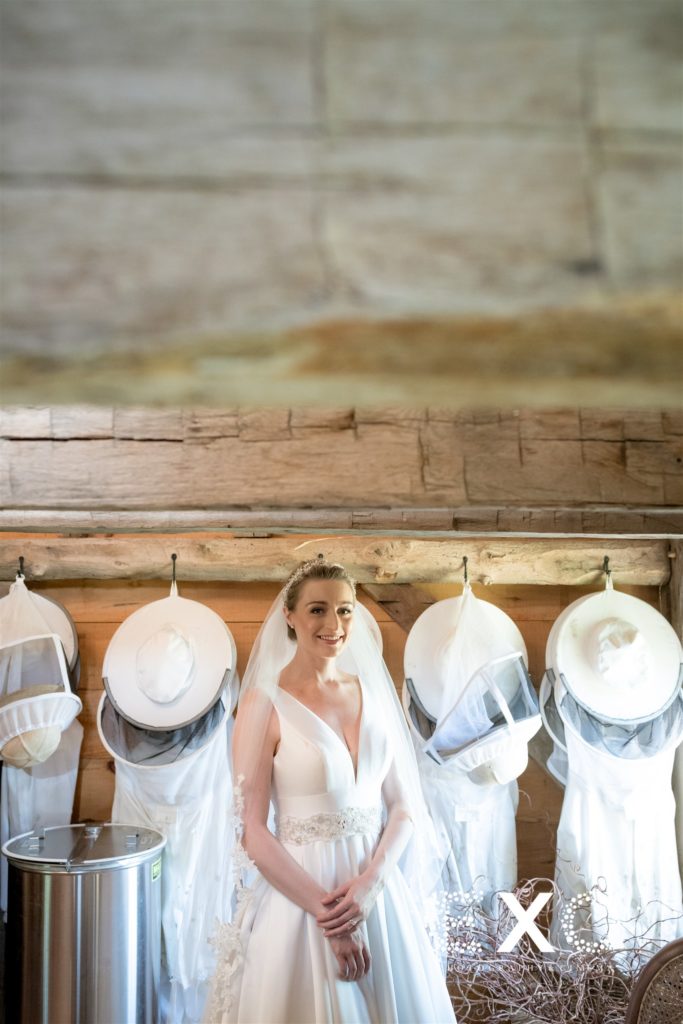 bride smiling with beekeepers uniform at Salt Air Farm