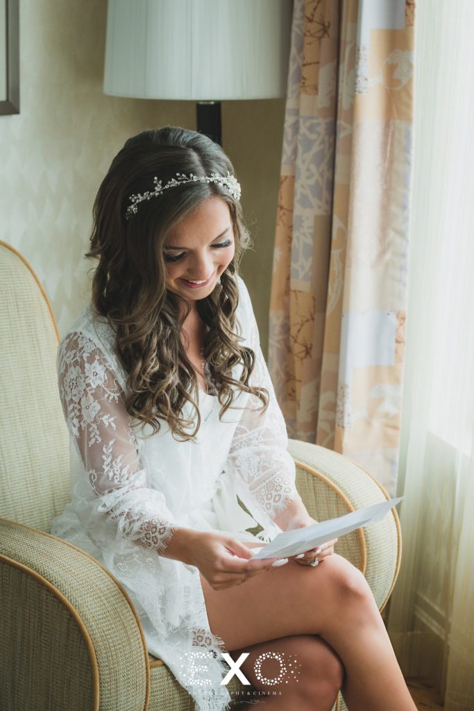 bride reading a letter before her wedding at Crescent Beach Club