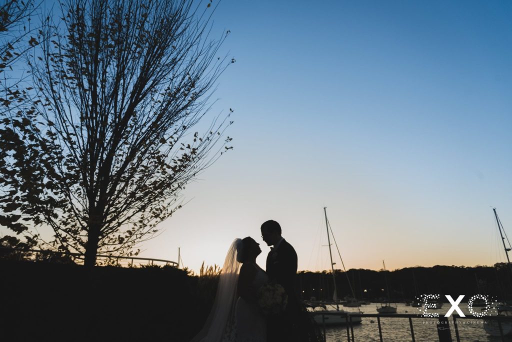 bride and groom holding each other at sunset at Harbor Club at Prime
