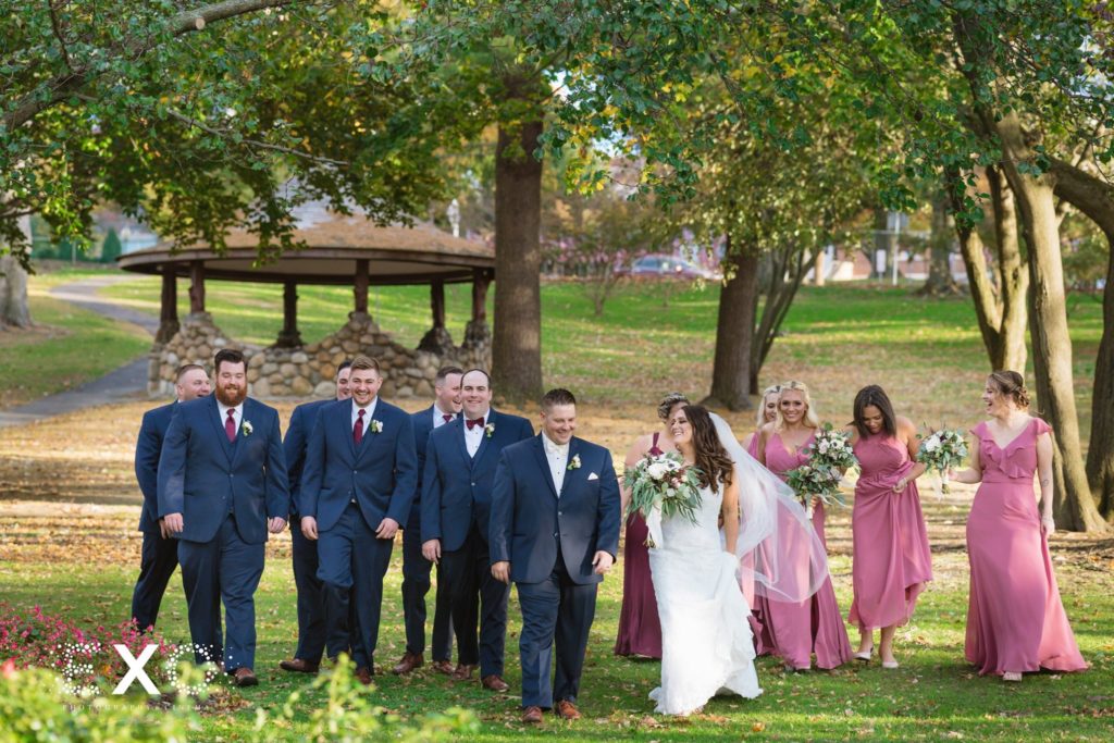 bride and groom with bridal party walking the grounds of Fox Hollow