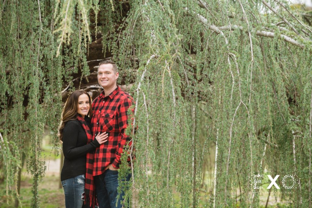 couple smiling within the greenery at Planting Fields Arboretum