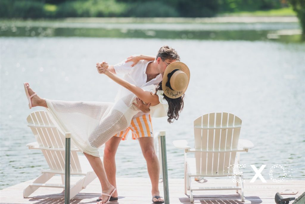 bride and groom dip kissing on dock