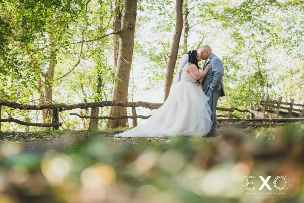 bride and groom kiss in woods