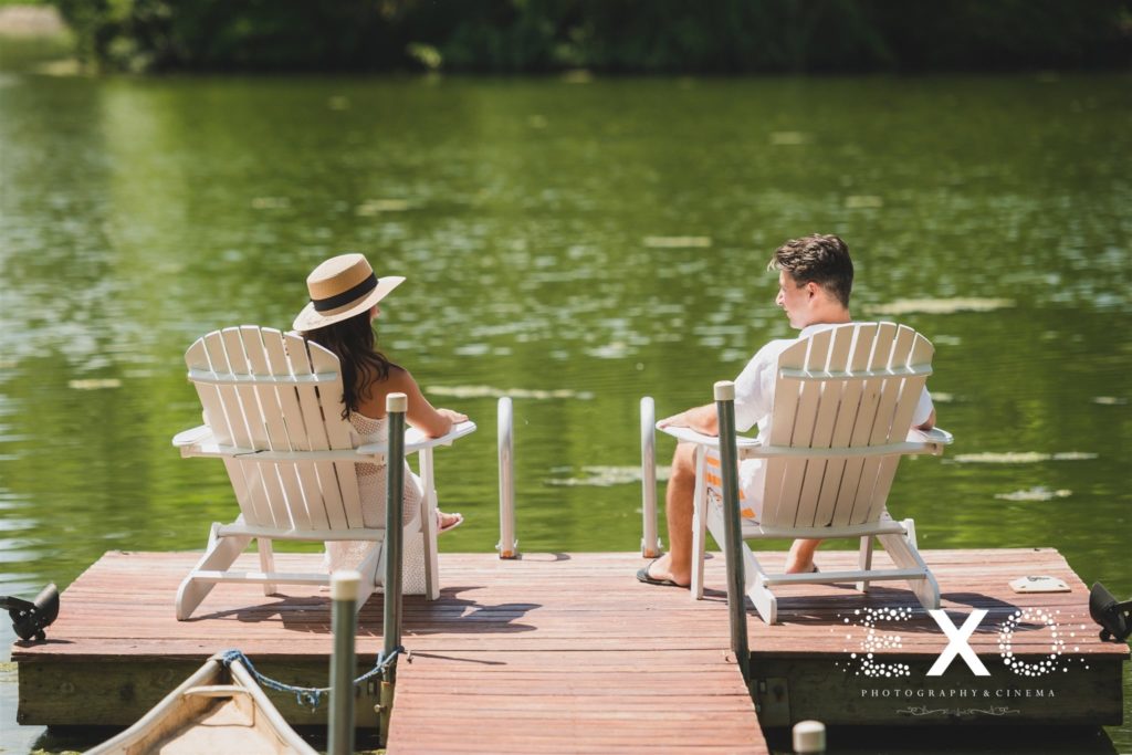 bride and groom sitting on chairs on dock