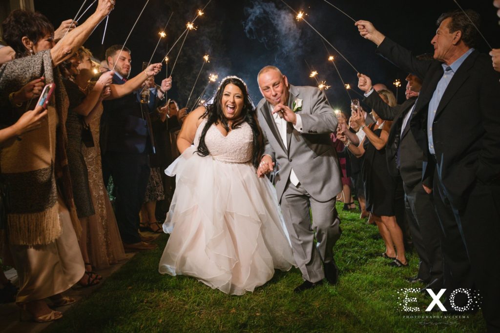 bride and groom walk under sparklers