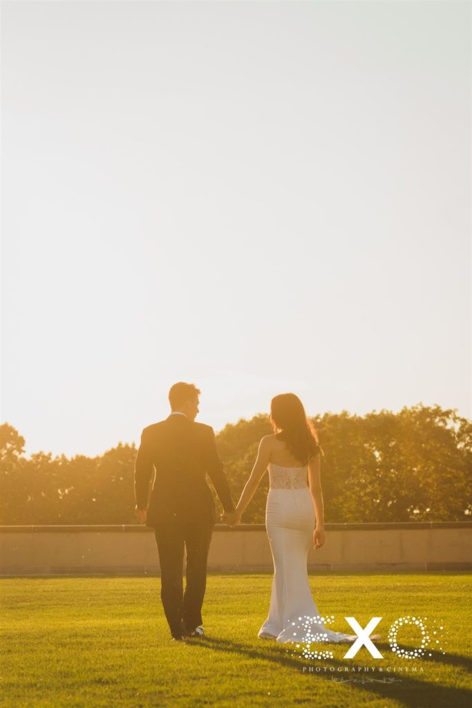 bride and groom walking in sunset