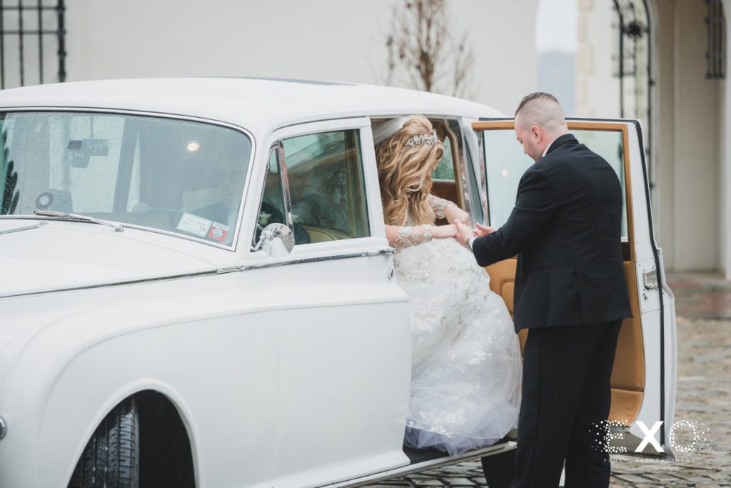 groom helping bride out of car