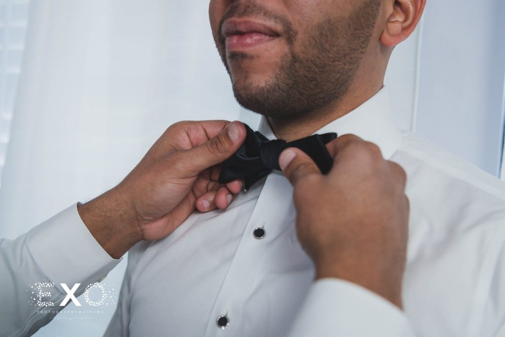 putting on grooms bowtie