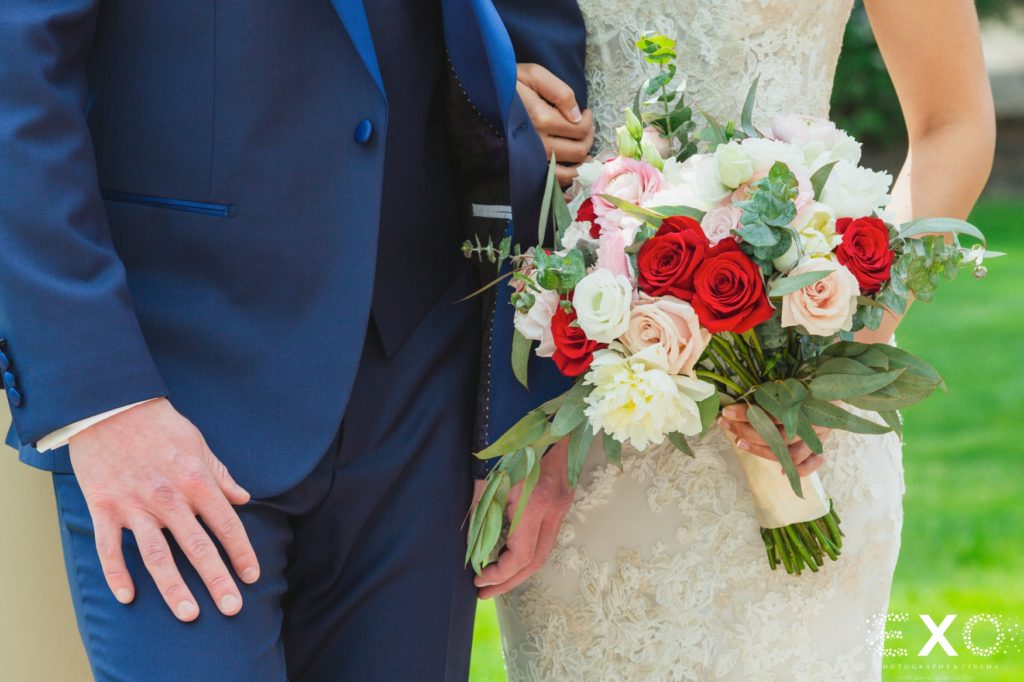 Bride and grooms waist with bouquet. 