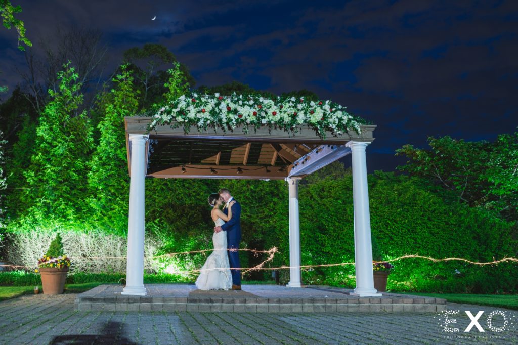 Bride and groom outside holding each other at night.