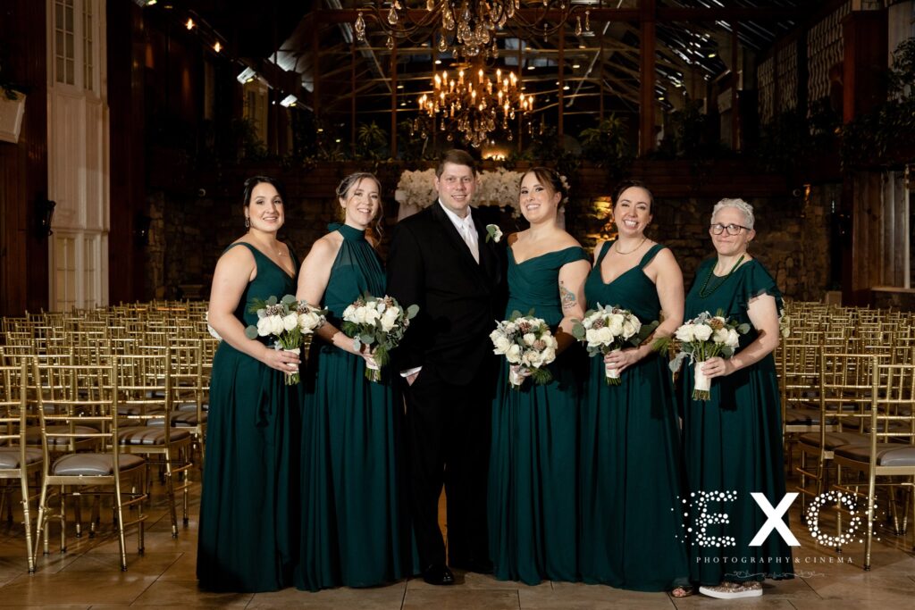Hunter green bridesmaids with the groom