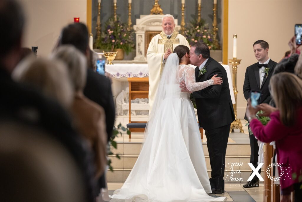 Dad kissing his bride at church