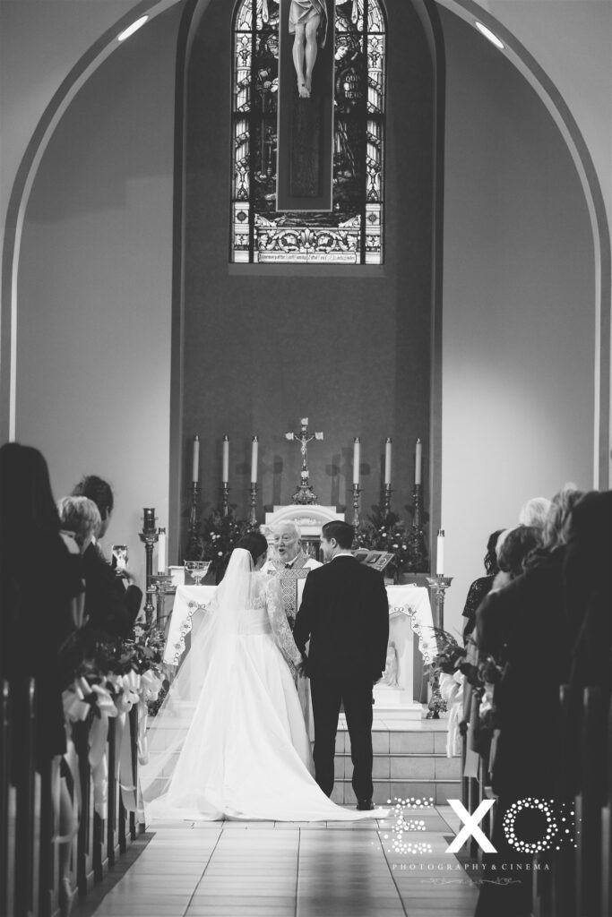 Black and white photo of bride and groom at church