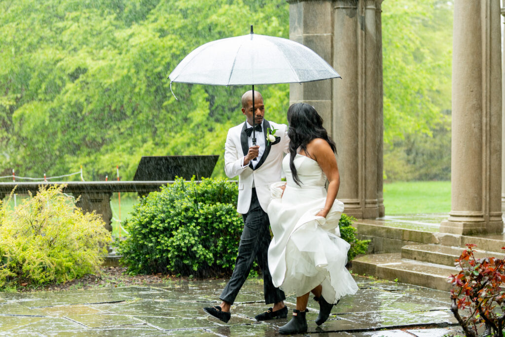 Bride and groom walking in the rain at Planting Fields